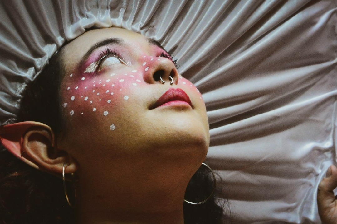 Retrato con maquillaje rosa y orejas élficas