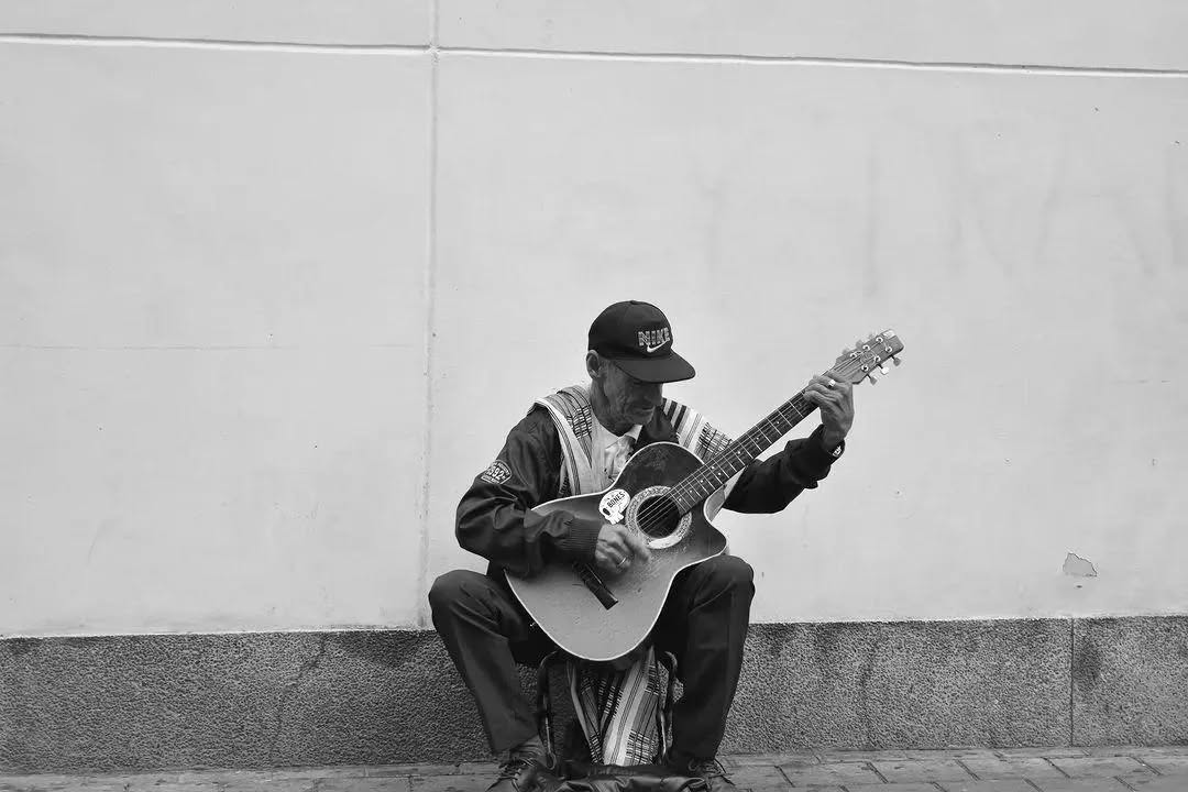 Hombre tocando guitarra en blanco y negro